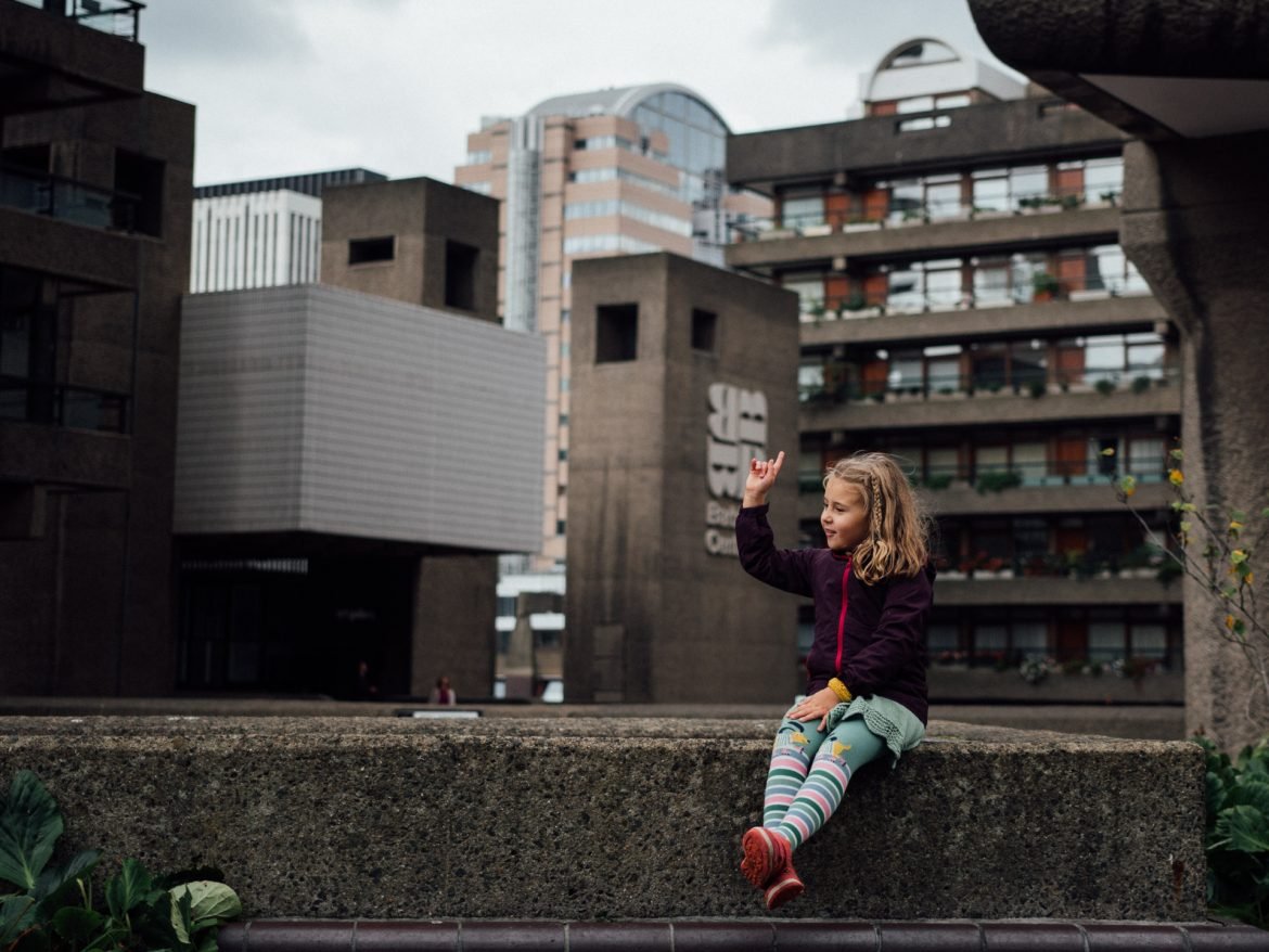 Girl sitting in front of the Barbican