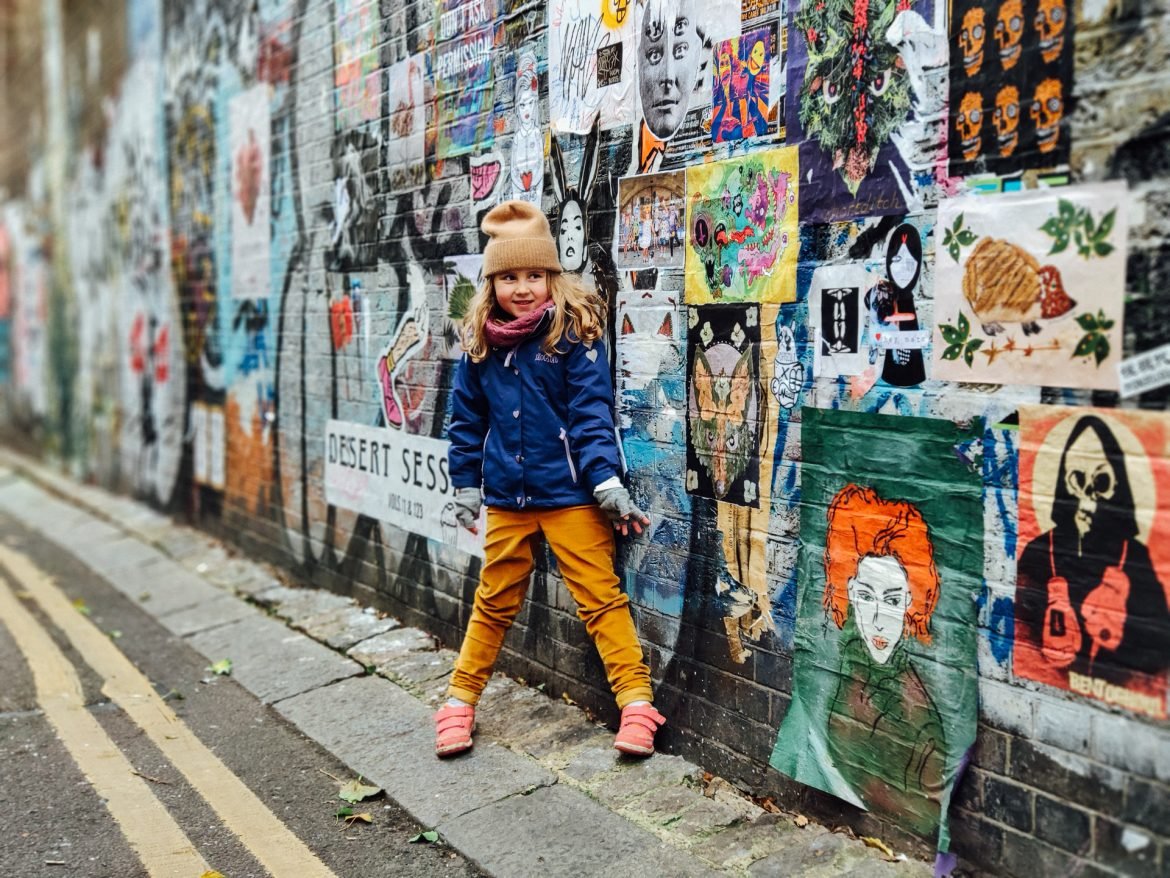 Girl in front of street art in East End